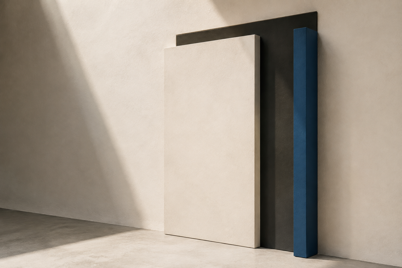 Three architectural panels in warm white, charcoal, and Frontwall blue leaning against a textured wall